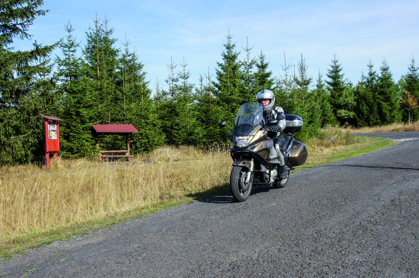 Motorrad auf einer Kammstraße durch Wald und Wiesen des Erzgebirges